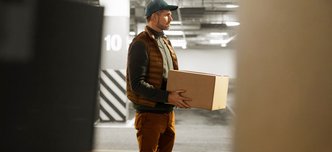 wp-5a7511001d84aae3-side-view-delivery-man-with-package