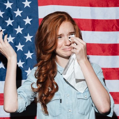 wp-5f199b0d0538ce3b-sad-redhead-young-lady-cry-usa-flag-looking-aside