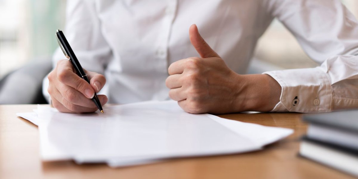 wp-78a519f1f44322a1-woman-writing-showing-thumbs-up (1)