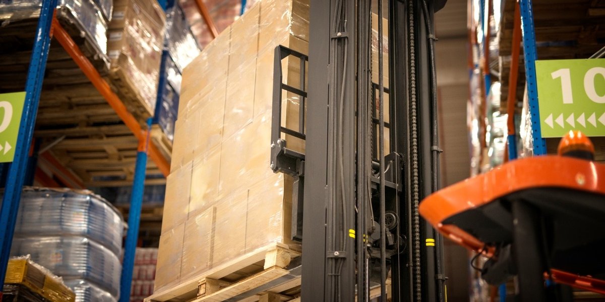 wp-9de0ab316aec7bb8-industrial-forklift-machine-lifting-palette-full-cardboard-boxes-placing-them-sh