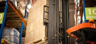 wp-9de0ab316aec7bb8-industrial-forklift-machine-lifting-palette-full-cardboard-boxes-placing-them-sh