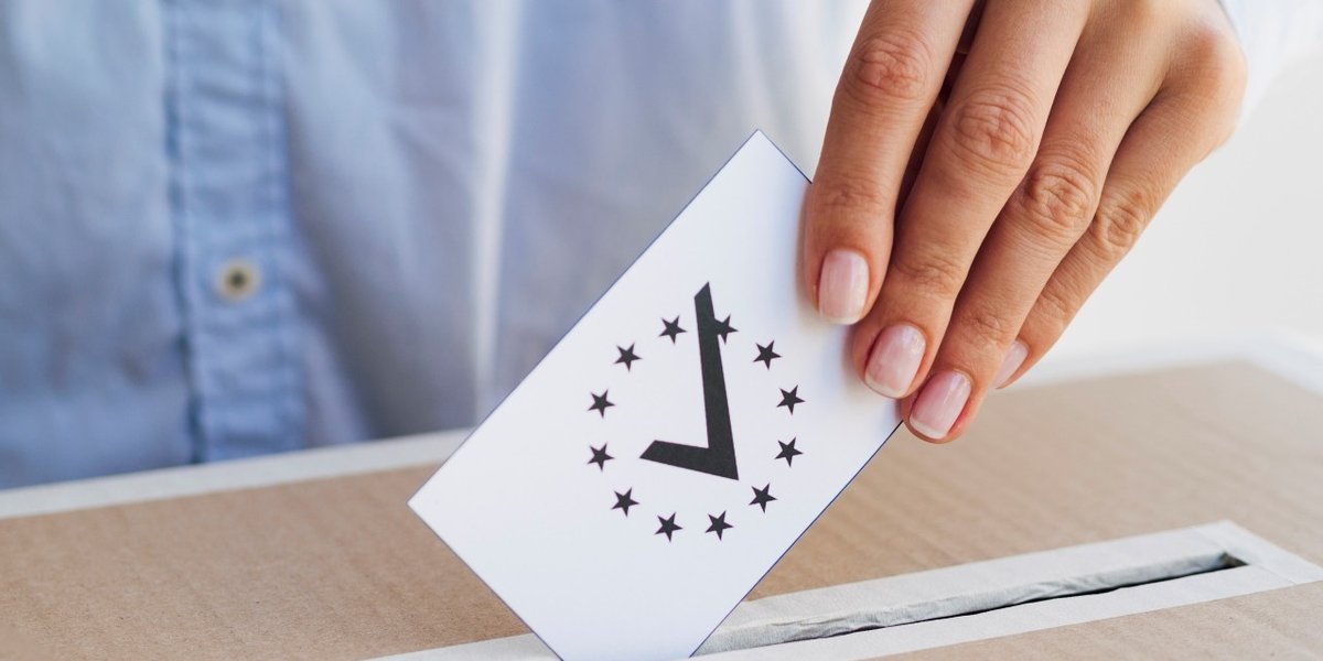 wp-c186abb23a2ec62c-woman-putting-checked-european-ballot-box