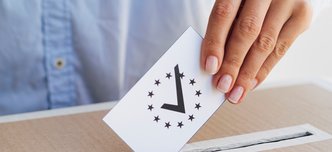 wp-c186abb23a2ec62c-woman-putting-checked-european-ballot-box