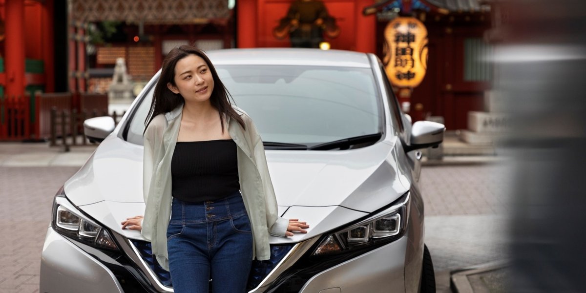 wp-c8af6b8aace456a0-woman-posing-her-new-electric-car