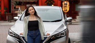 wp-c8af6b8aace456a0-woman-posing-her-new-electric-car