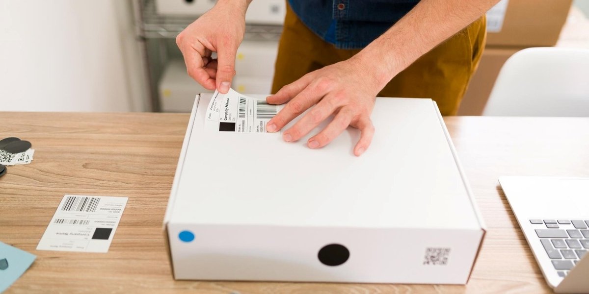 wp-e0d10b00a16d3ab4-close-up-male-hands-putting-shipping-label-package-arranging-online-customers-or