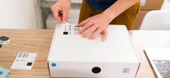 wp-e0d10b00a16d3ab4-close-up-male-hands-putting-shipping-label-package-arranging-online-customers-or