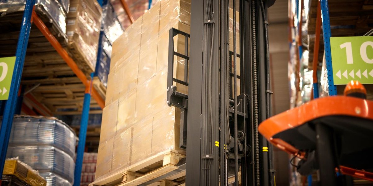 wp-e4a370480147287d-industrial-forklift-machine-lifting-palette-full-cardboard-boxes-placing-them-sh